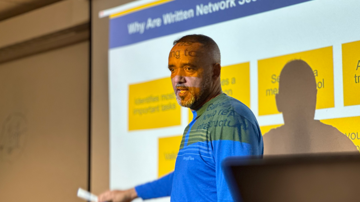 Professor Kidane Sengal lecturing for a graduate cybersecurity class.