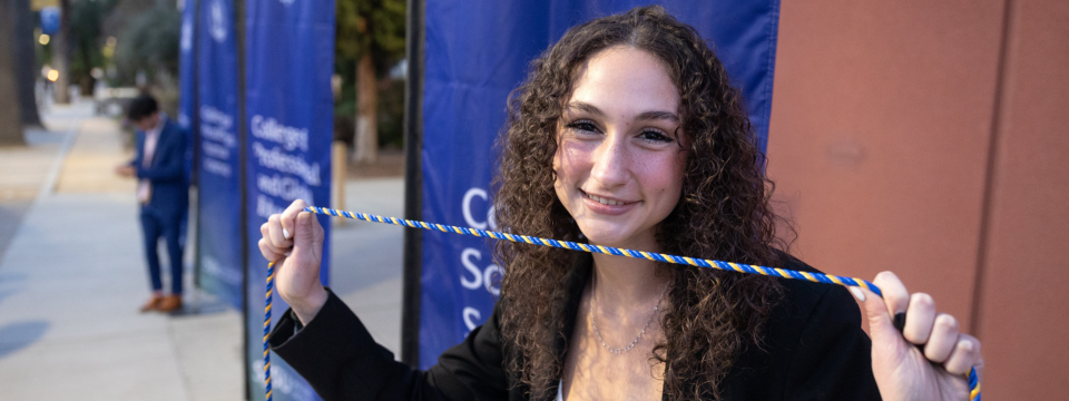 SJSU student holding an honor cord. Photo by Jim Gensheimer.
