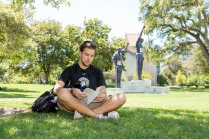 Student studying on Carlos lawn