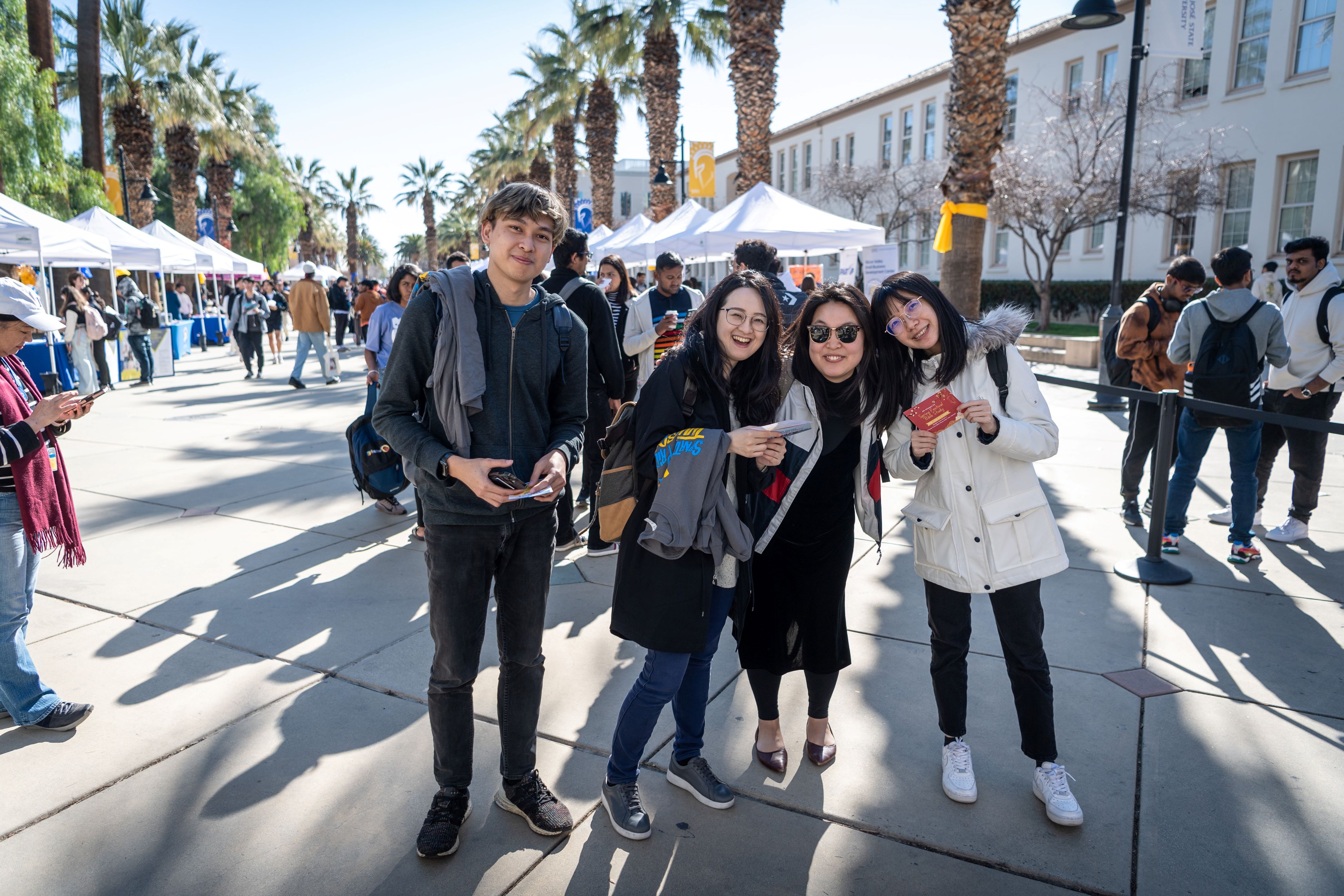A family of four pose on a sunny day on the SJSU Paseo