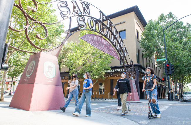 Students walking past San Pedro Square's entrance in downtown San Jose.